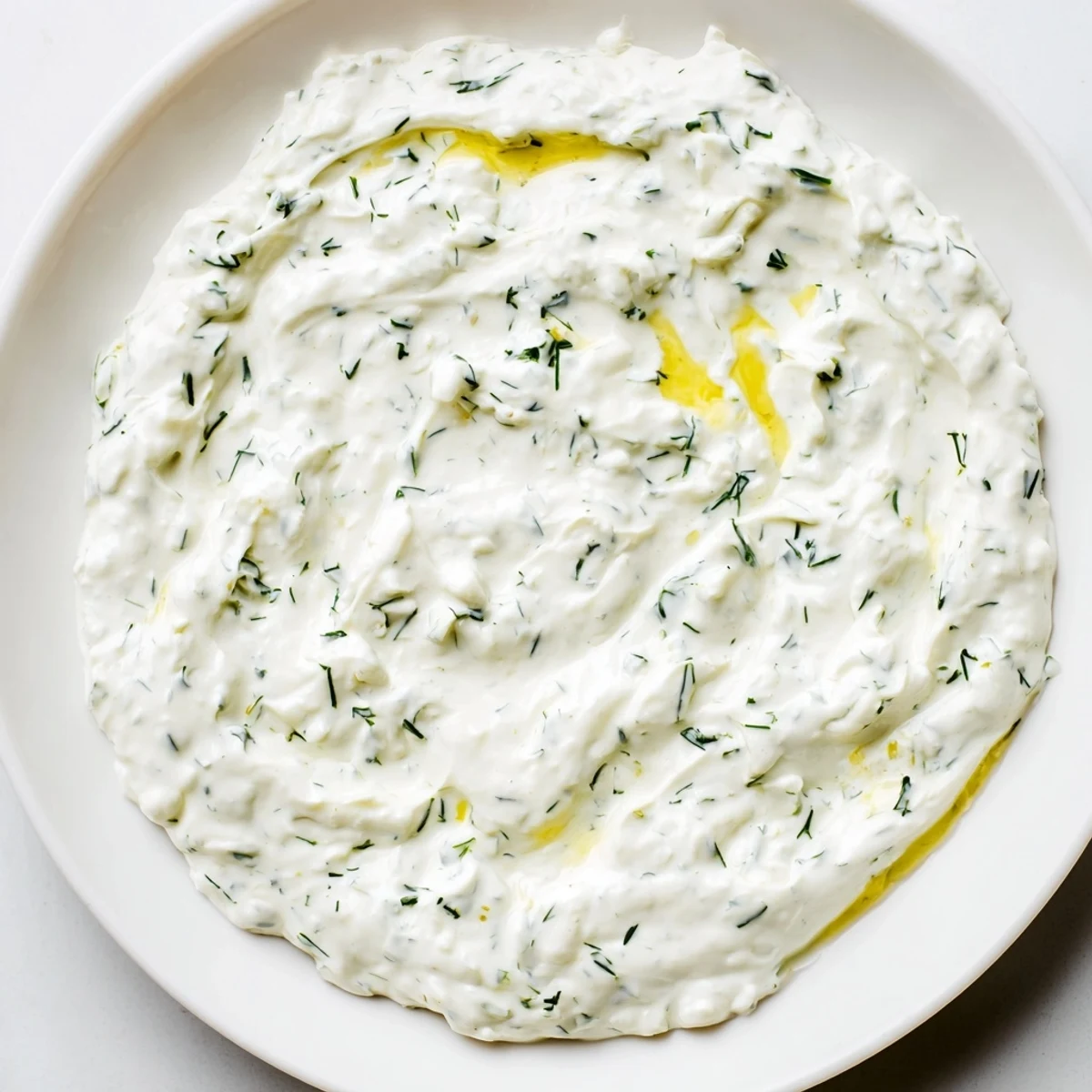 Creamy Greek Yogurt Ranch Dip, studded with fresh herbs, is ready to be scooped with crisp veggies.