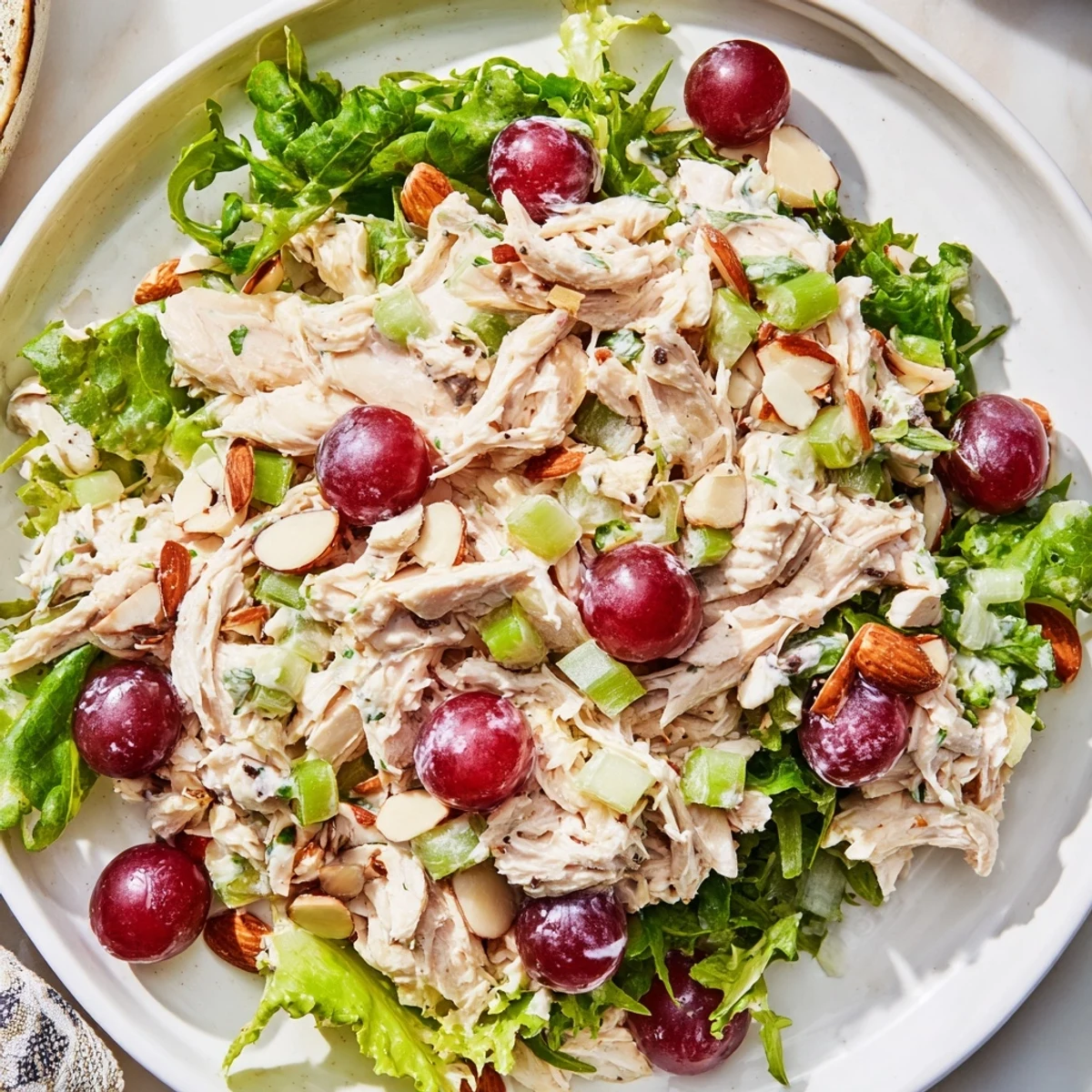 A close-up shot of creamy, juicy Crispy Chicken Salad over fresh salad greens.