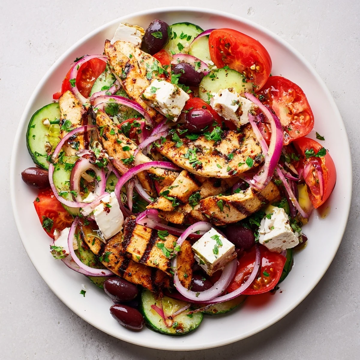Greek salad with grilled chicken: colorful, fresh salad with juicy grilled chicken atop.