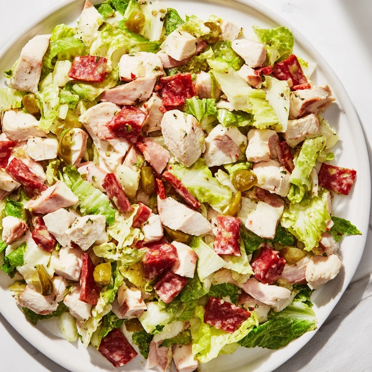 A hearty bowl of Italian Deli Chopped Chicken Salad with salami, provolone, and pepperoncini tossed in vinaigrette.