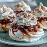 Eight Mini Hot Toddy Pavlovas served as elegant individual desserts, featuring airy meringue and warmly spiced pear topping.