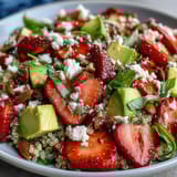 Colorful strawberry avocado quinoa salad featuring ripe strawberries, diced avocado, and fresh greens for a healthy lunch.  