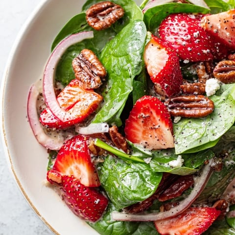 Fresh, vibrant Strawberry Spinach Salad with bright red strawberries and candied pecans, calling everyone!