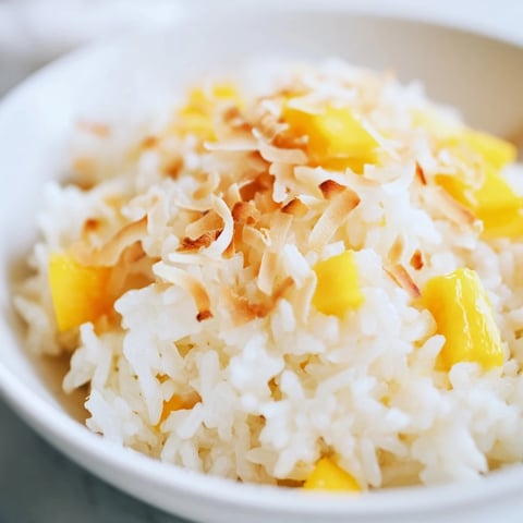 Steamed jasmine rice simmered in creamy coconut milk, lightly sweetened and topped with toasted coconut flakes and fresh mango.