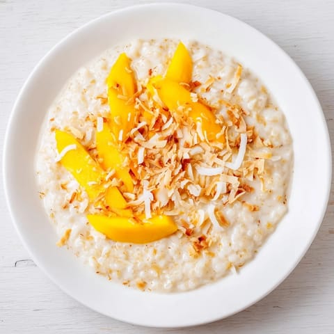 Warm bowl of Toasted Coconut Rice Pudding with visible rice grains and sweet coconut aroma.