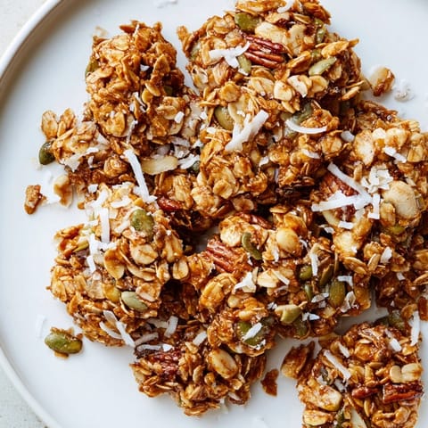 Crispy Honey Nut Granola Clusters, baked to a perfect crisp, are loaded with nuts, honey, and oats.