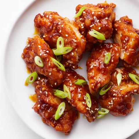 Sweet and Spicy Sriracha Honey Chicken, glistening with a vibrant glaze, ready for dinner with rice.