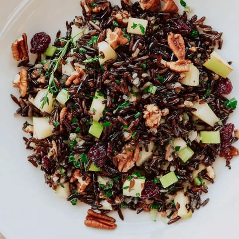 Wild Rice Harvest Salad served as a hearty side dish, featuring nutty grains, sweet apple chunks, and vibrant green onions.  