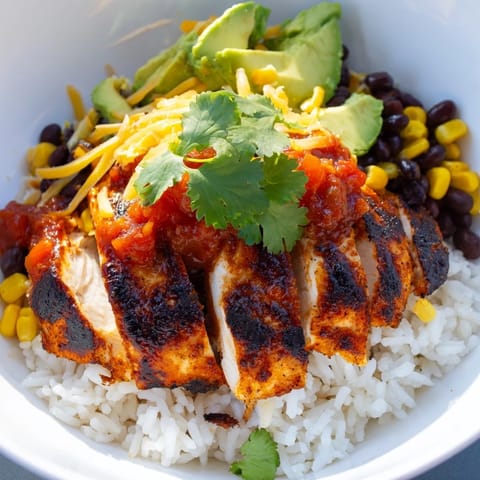 A close-up of a vibrant Tex-Mex burrito bowl topped with zesty salsa and melted cheese.  