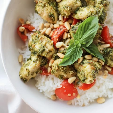 A vibrant Chicken Pesto Rice Bowl with golden chicken, fluffy rice, and fresh tomato chunks, ready for a quick weeknight meal.