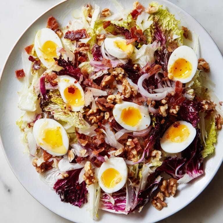 Freshly tossed Bitter Greens Salad with Warm Bacon Dressing, featuring crispy bacon pieces and wilted greens.