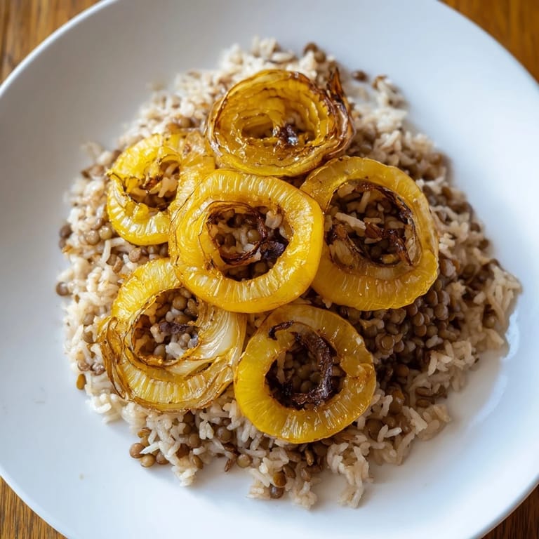 Golden caramelized onions crown a bowl of flavorful Lebanese Mjadra, ready to serve.