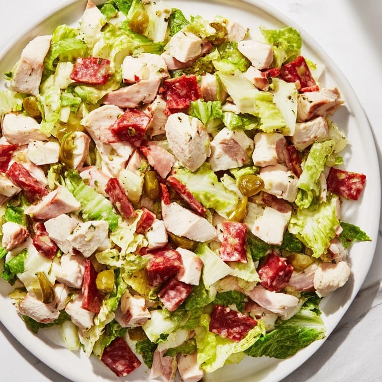 A hearty bowl of Italian Deli Chopped Chicken Salad with salami, provolone, and pepperoncini tossed in vinaigrette.