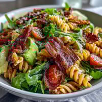 Creamy BLT Pasta Salad with Bacon and Avocado, loaded with crisp romaine, juicy cherry tomatoes, and tender pasta in a tangy dressing.